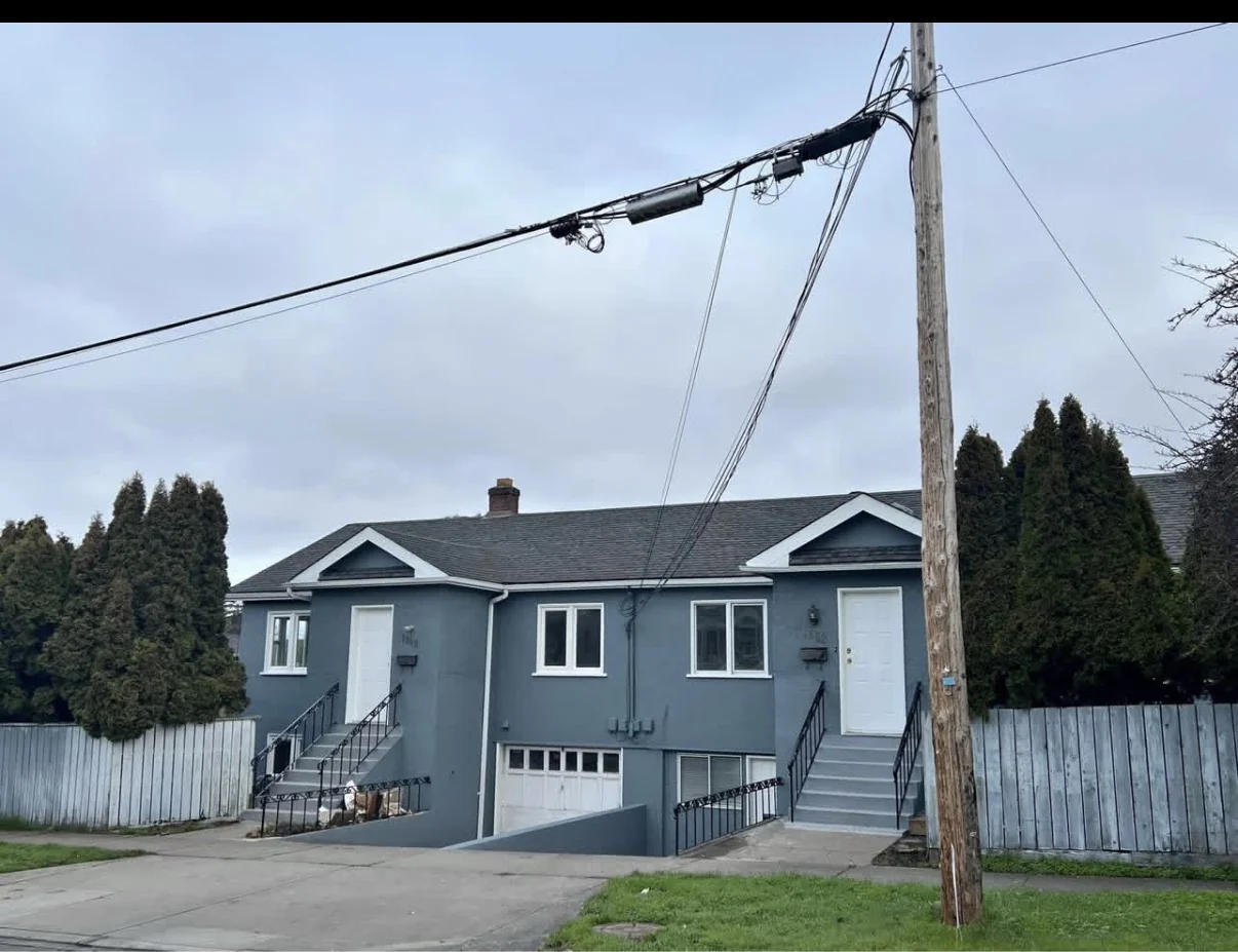 Completed exterior repaint on a single-level residential home with white trim